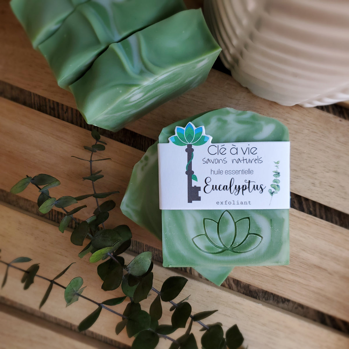 Savon Eucalyptus Clé à vie vert et crème, avec son étiquette, sur un porte-savon en bois